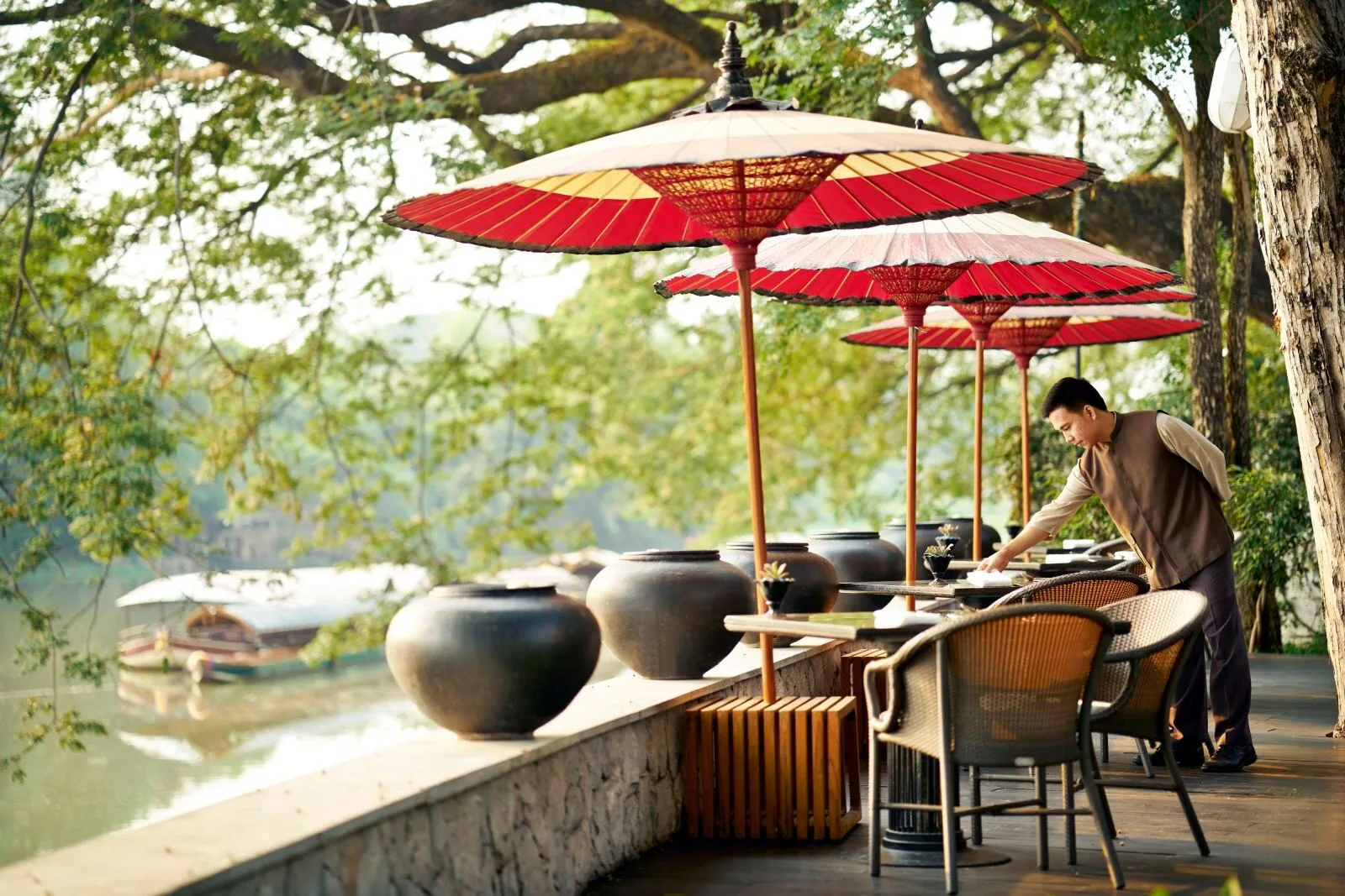 Anantara Chiang Mai Resort &mdash; riverside seating under Lanna parasols