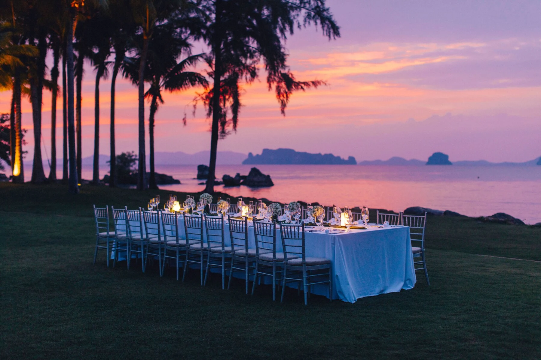 Dinner set on the lawn at Phulay Bay at sunset